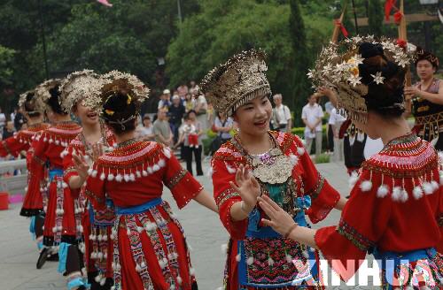 4月25日,一群苗族少女在广东鼎湖山风景区表演迎宾舞.